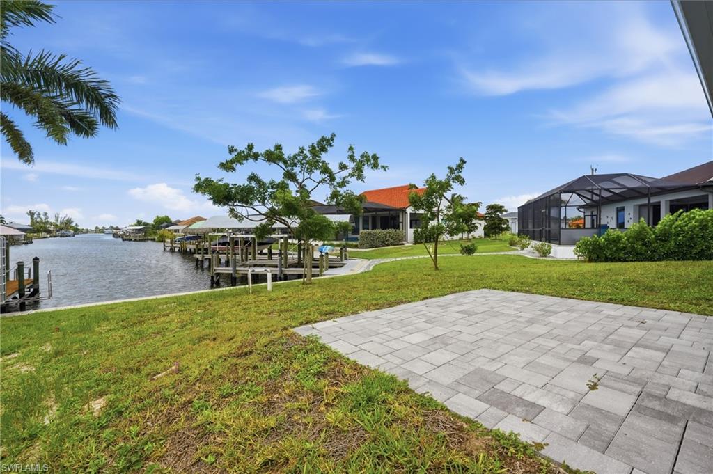 Expansive waterfront property featuring a paver patio and ample green space