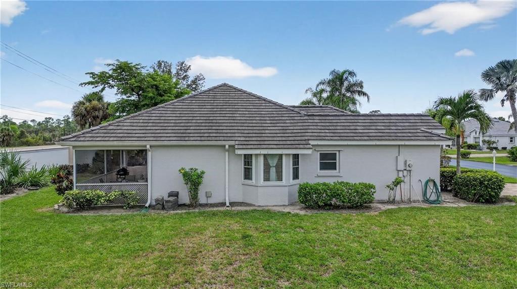 Exterior featuring a neutral stucco finish, a screened lanai, a bay window, and a textured shingle roof