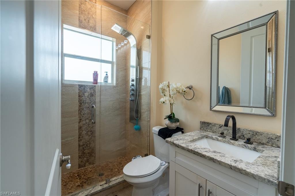 Modern bathroom featuring a walk-in shower with glass enclosure, decorative tile accent, and rainfall showerhead