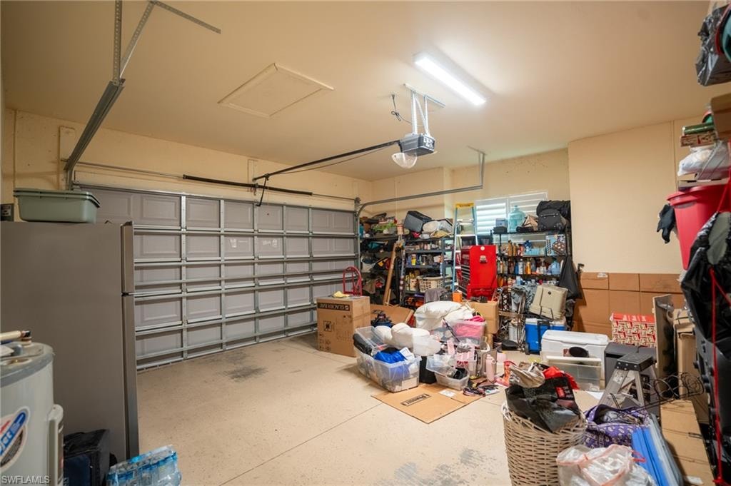 Spacious garage featuring a paneled overhead door, concrete flooring, and overhead lighting