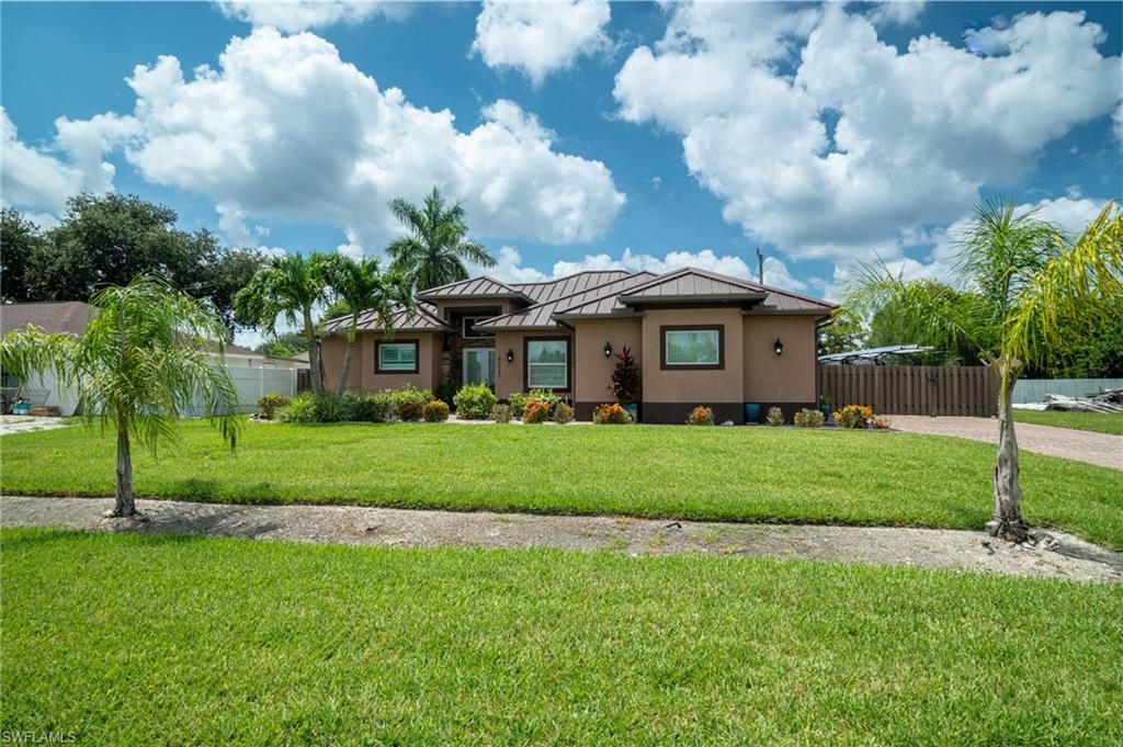 Contemporary-style residence with a stucco exterior, a tile roof, and a meticulously manicured front lawn