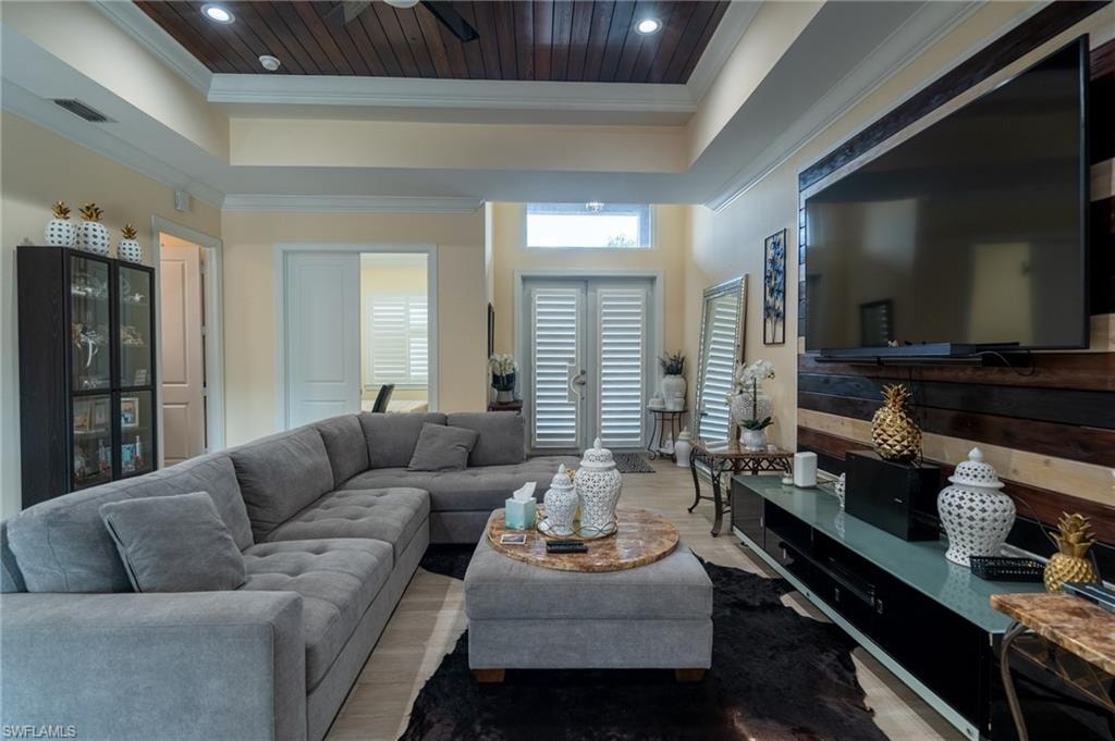 Spacious living area featuring a wood-panel ceiling, light-toned walls, and wood-finish flooring