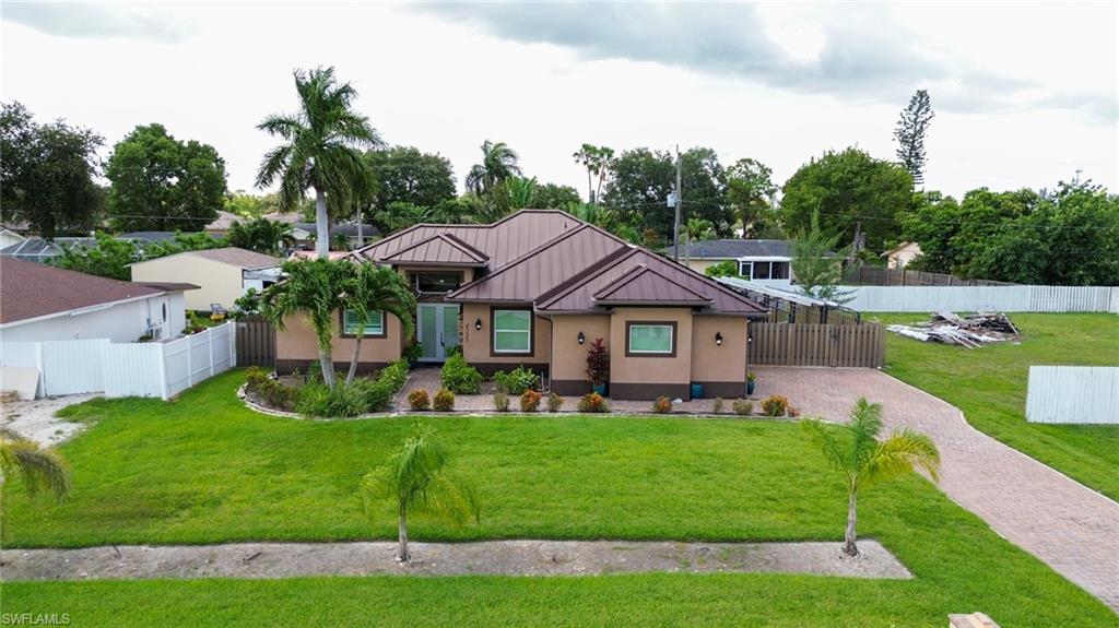 Contemporary single-story residence featuring a metal roof and stucco exterior