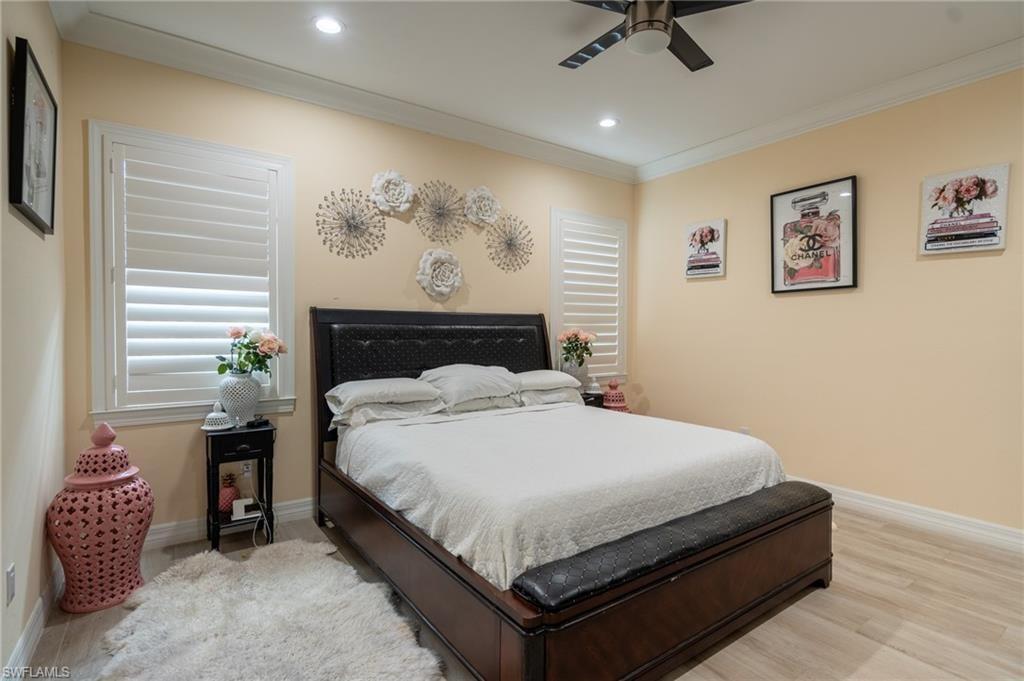 Bedroom featuring plantation shutters, recessed lighting, crown molding, a ceiling fan, and wood-finish flooring