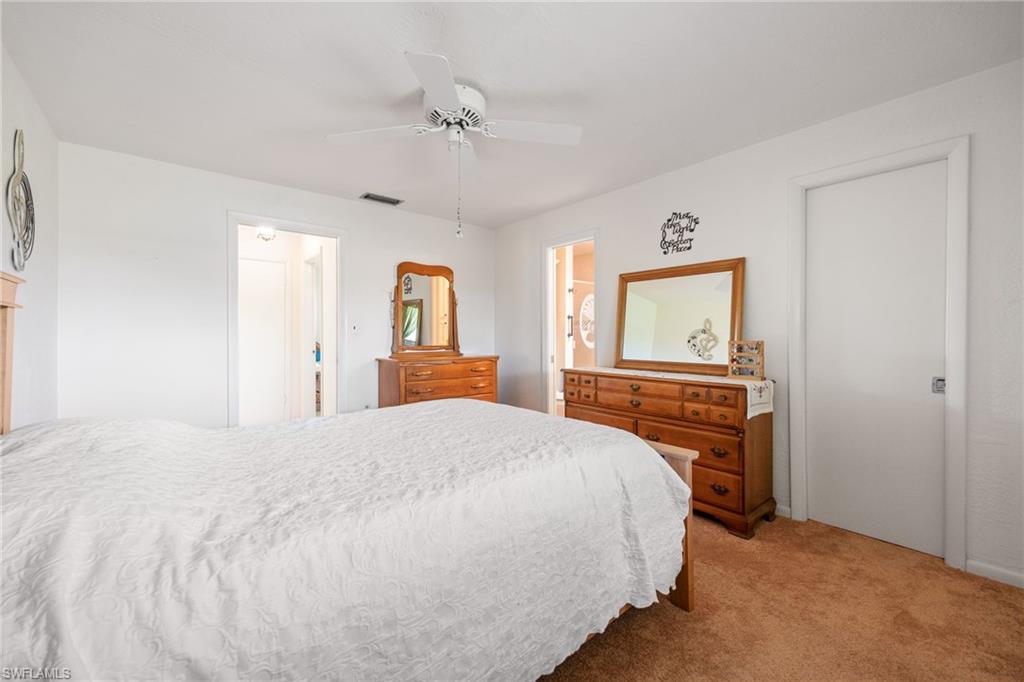 Bedroom featuring plush brown carpeting, a white ceiling fan, and white painted walls
