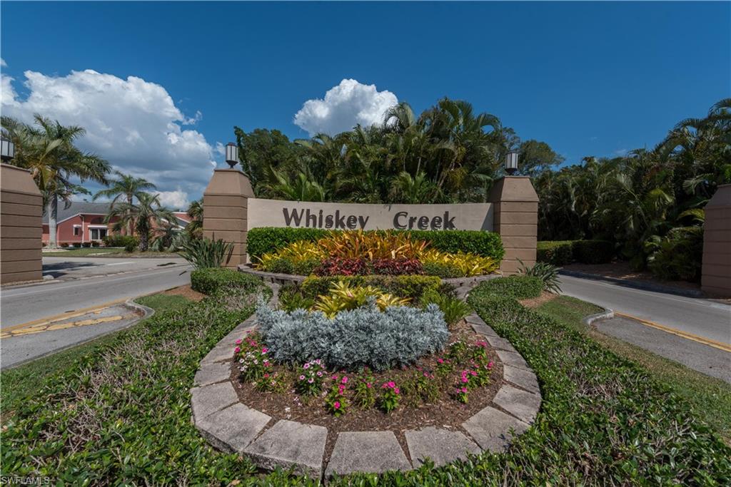 Community entrance signage featuring stucco pillars and a stone base