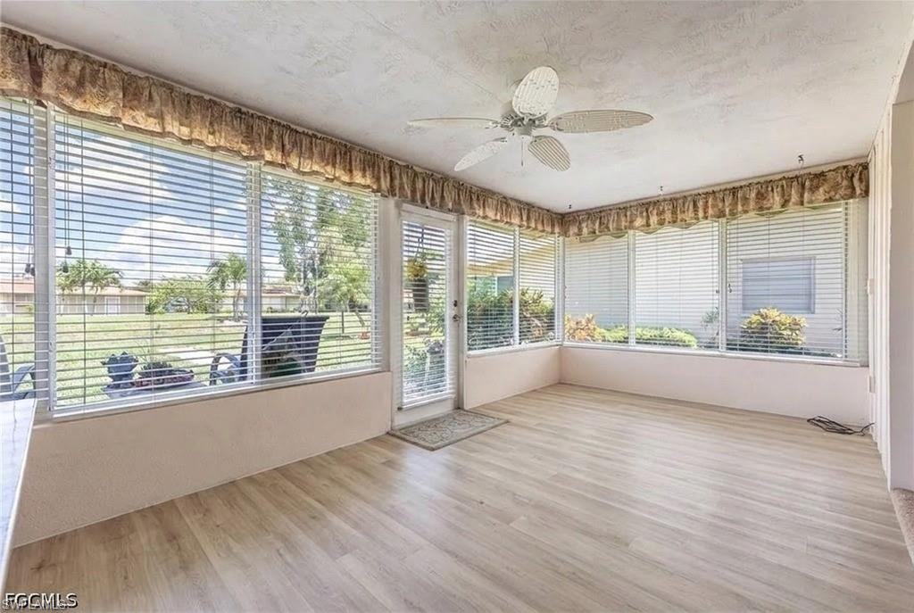 Virtual wood-finish flooring, ample natural light, and a ceiling fan