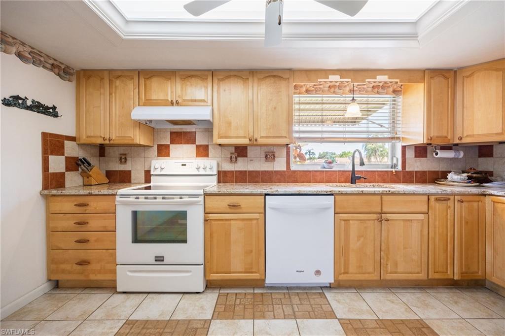 Kitchen featuring light wood cabinetry and stone-look countertops