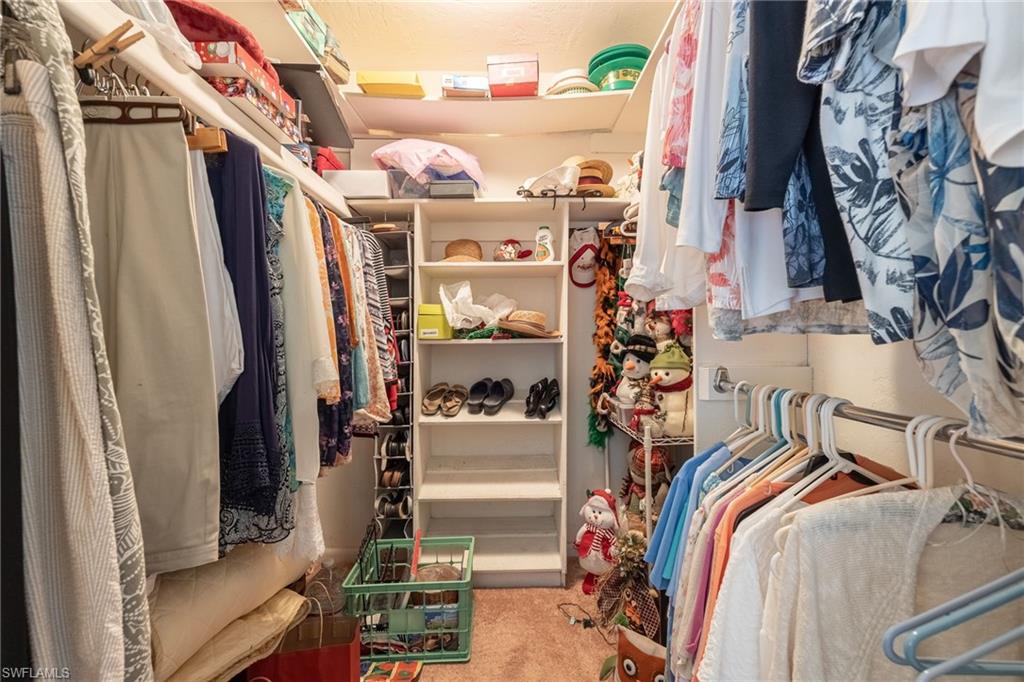 Walk-in closet featuring built-in shelving, multiple hanging rods, and recessed lighting