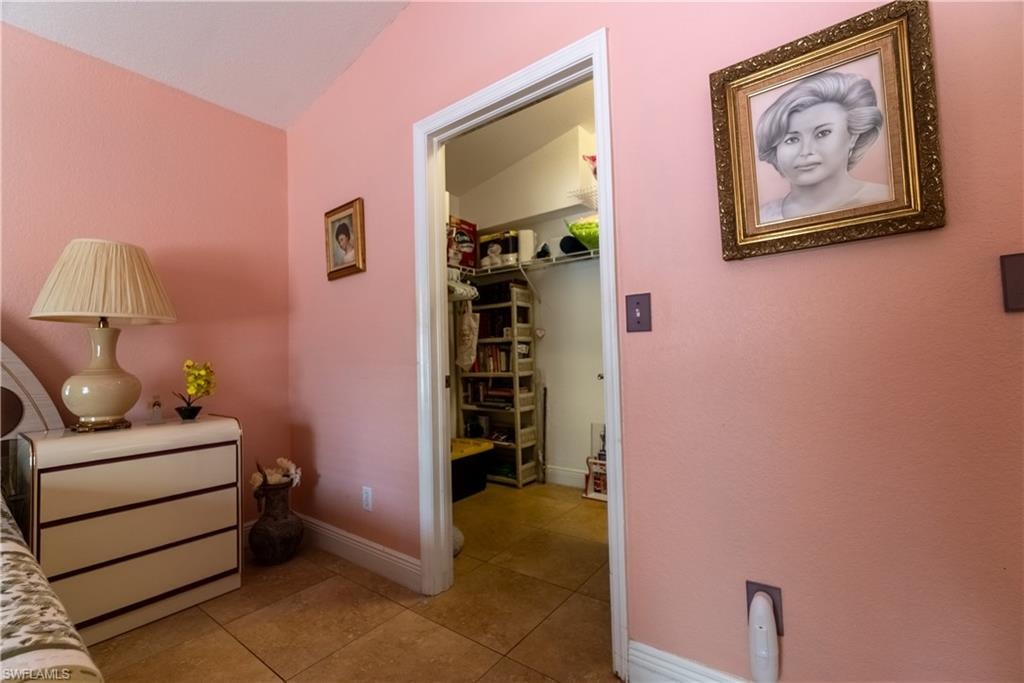 Hall with baseboards and light tile patterned floors