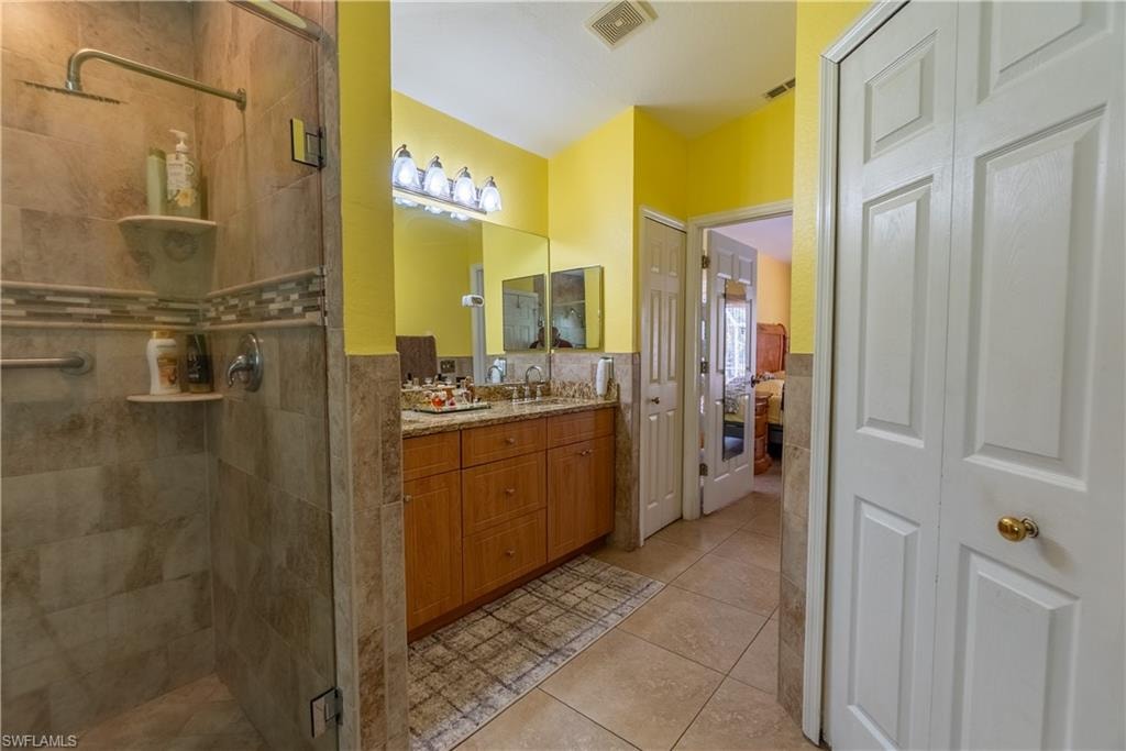 Bathroom with visible vents, a stall shower, and vanity