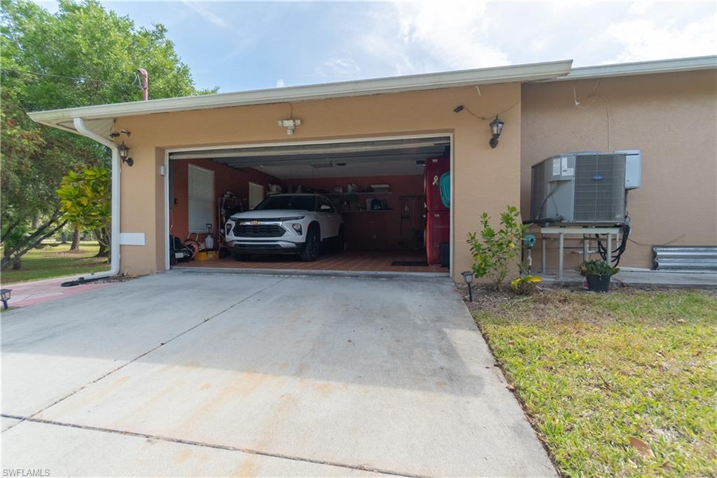 Garage with driveway and central AC unit