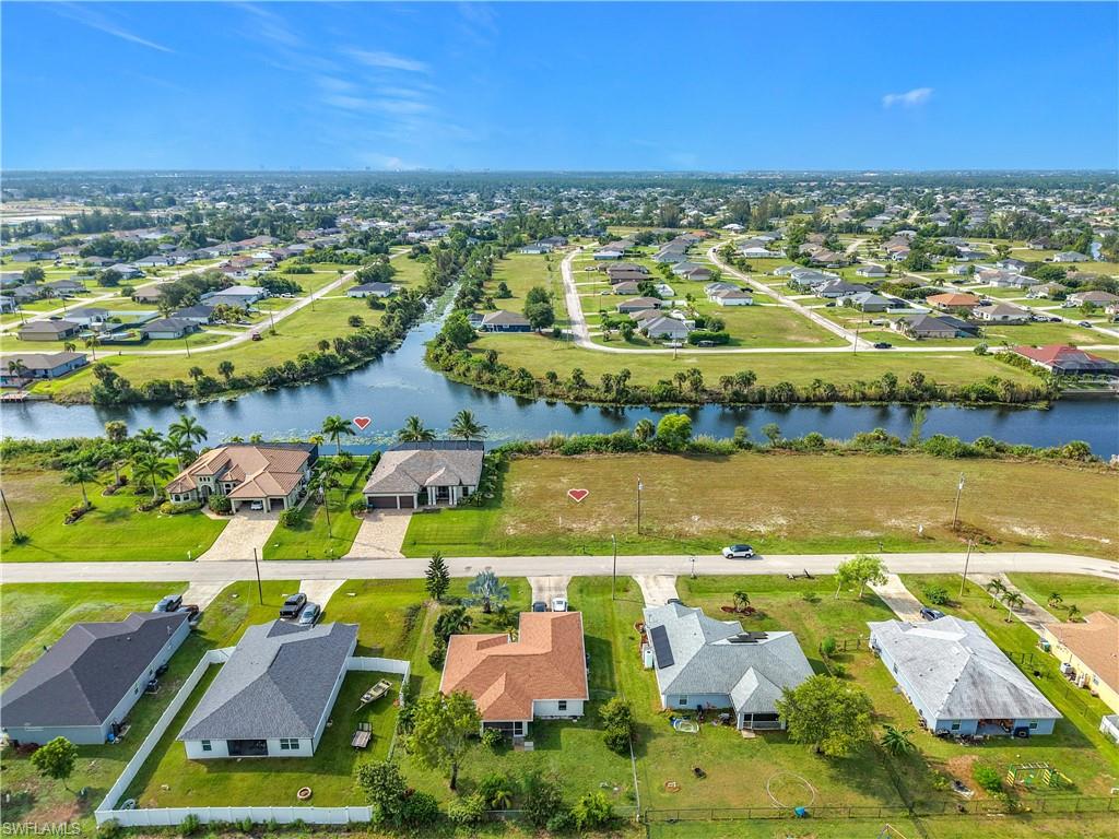 Expansive undeveloped lot featuring canal frontage and surrounding residential properties