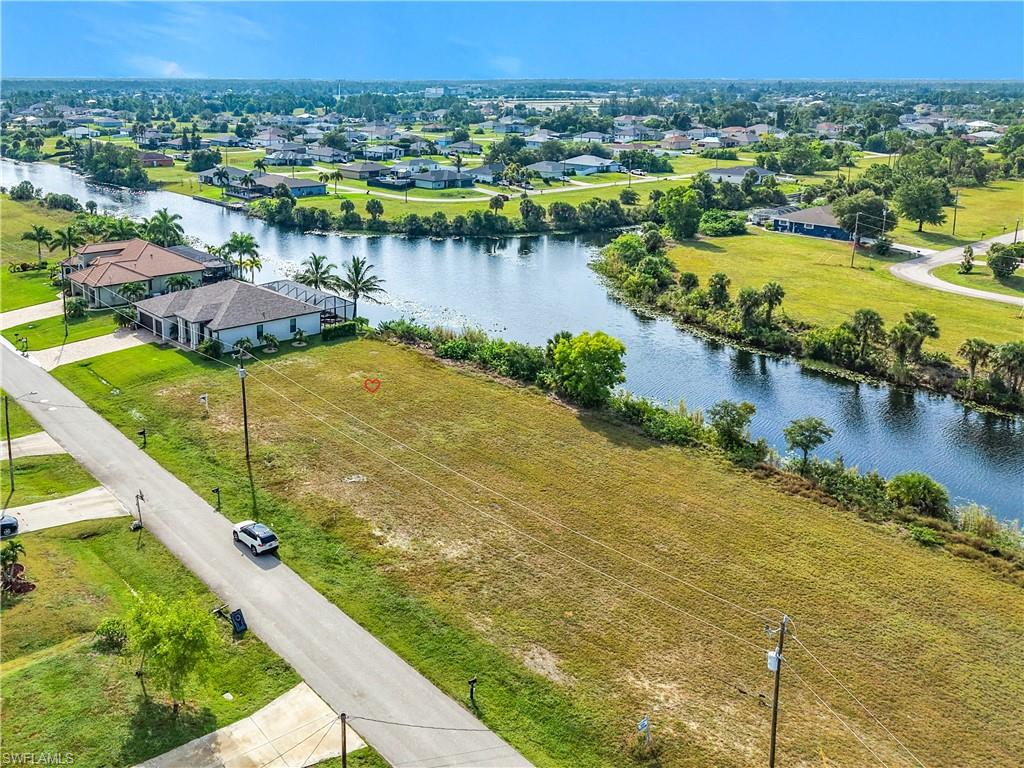 View of can intersection at Brothers Canal and Slough CanalExpansive cleared parcel featuring canal frontage, a verdant green lawn, and surrounding residential properties