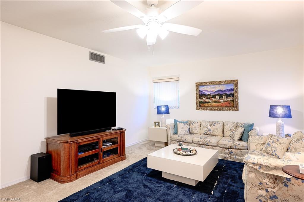 Living room featuring carpet and ceiling fan