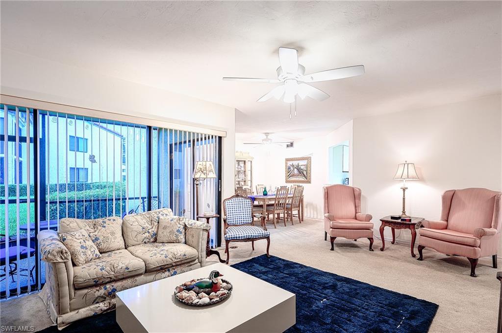 Carpeted living room with ceiling fan