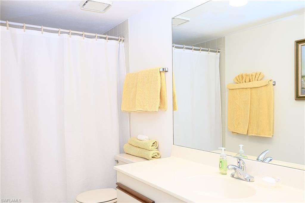 Bathroom featuring vanity, toilet, and a shower with curtain