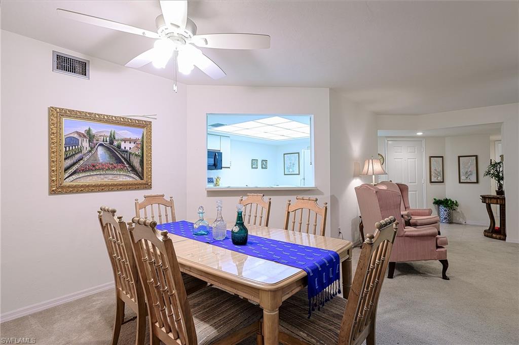 Carpeted dining area with ceiling fan