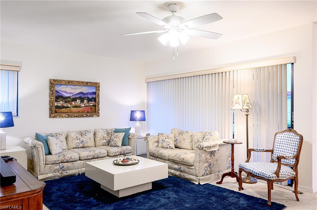 Carpeted living room Pic Painting over sofa is different.natural light and ceiling fan