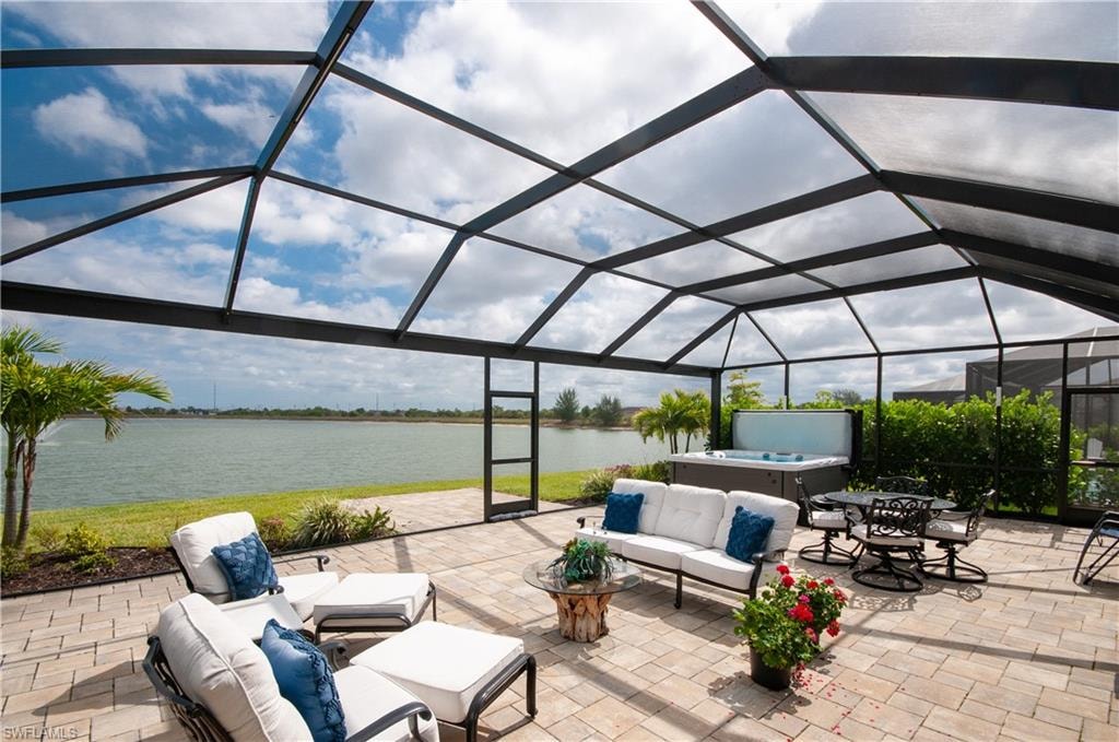 Screened patio featuring paver flooring, a built-in hot tub, and direct water frontage