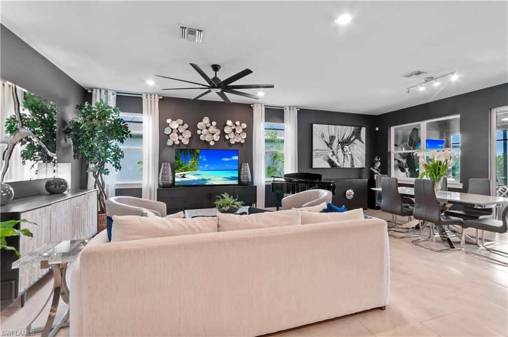 Open-concept living and dining area featuring dark accent walls and light-toned flooring