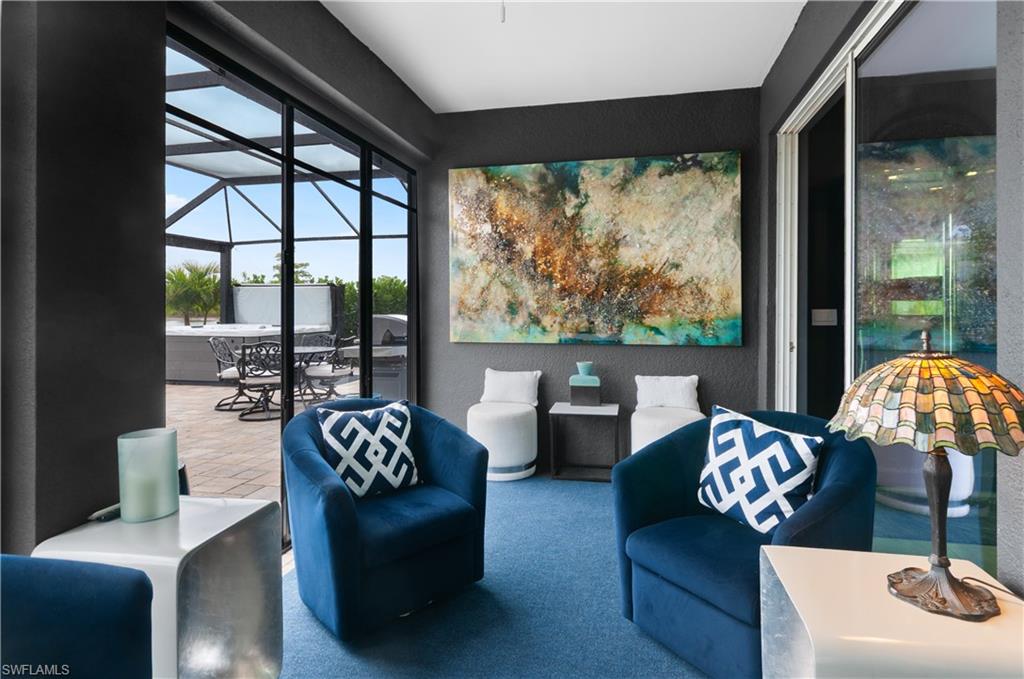 Interior space featuring dark accent wall, sliding glass doors, paver patio, screened enclosure, and spa