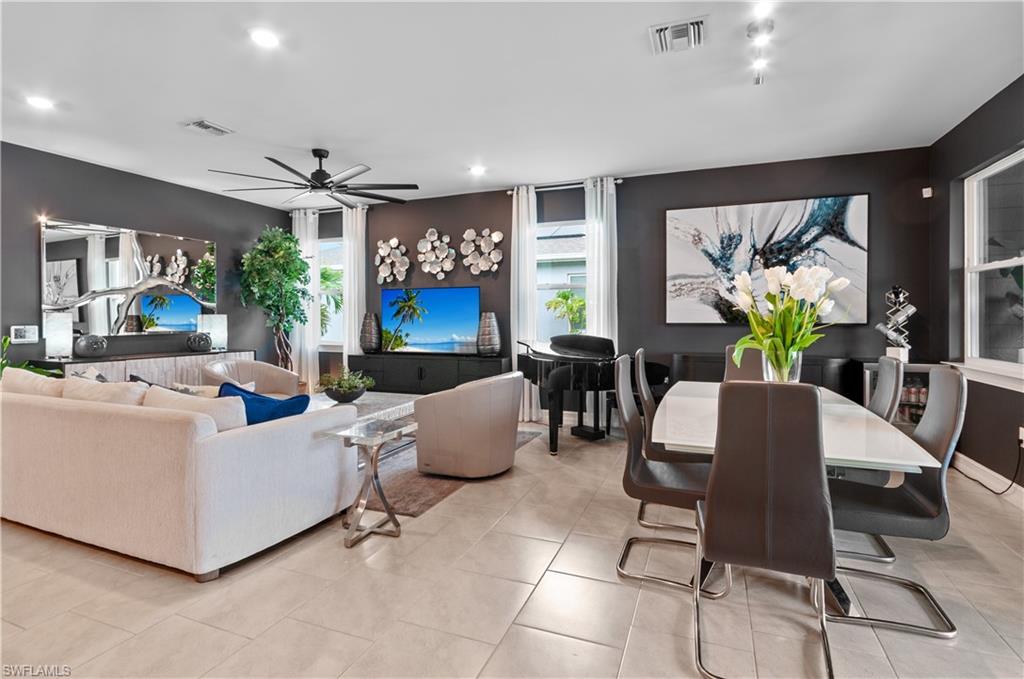 Open-concept living area featuring a black ceiling fan with integrated lighting, recessed lighting, and tile flooring