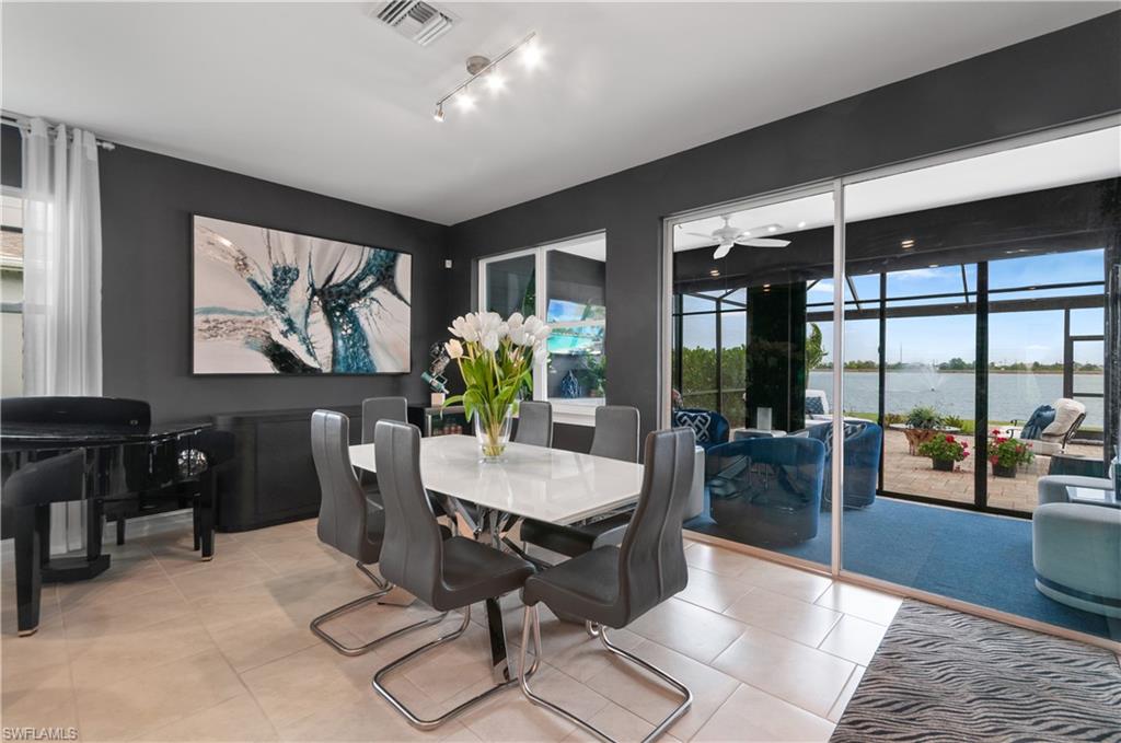 Spacious living area featuring neutral tile flooring, dark accent walls, and large sliding glass doors opening to a screened lanai