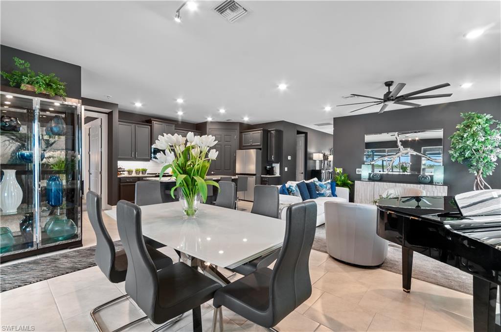 Open-concept living space featuring light-toned tile flooring and dark accent walls