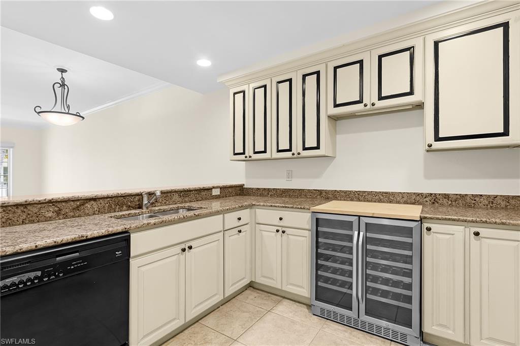 Kitchenette with light-toned cabinetry, granite countertops, and a dual-zone beverage refrigerator