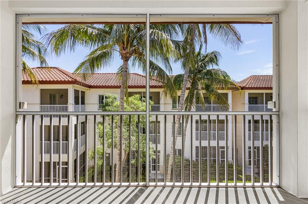 Screened balcony featuring a white railing and textured flooring