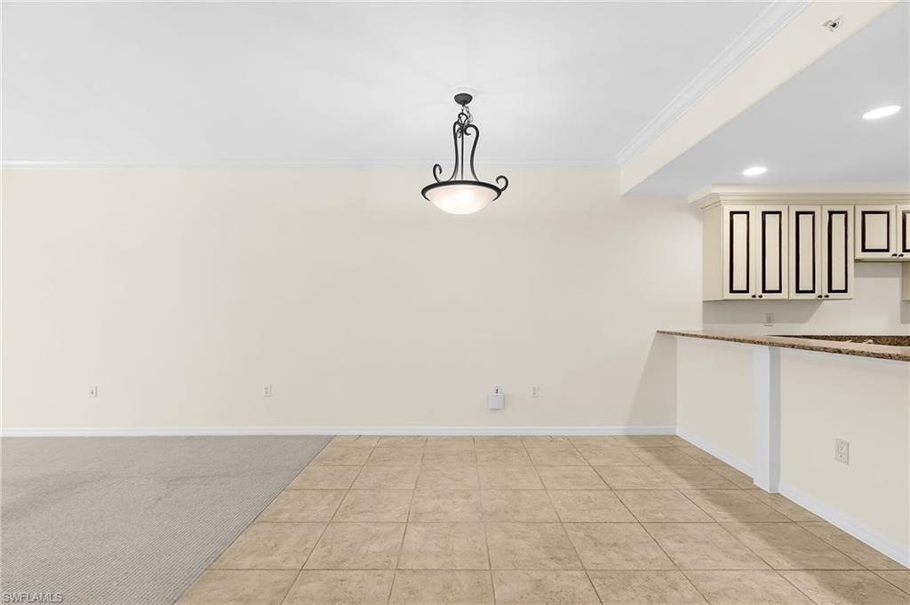 Open-concept living space featuring a combination of carpet and tiled flooring