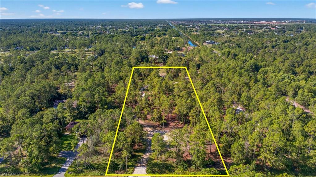 Aerial view of property and surrounding area featuring property parcel outlined