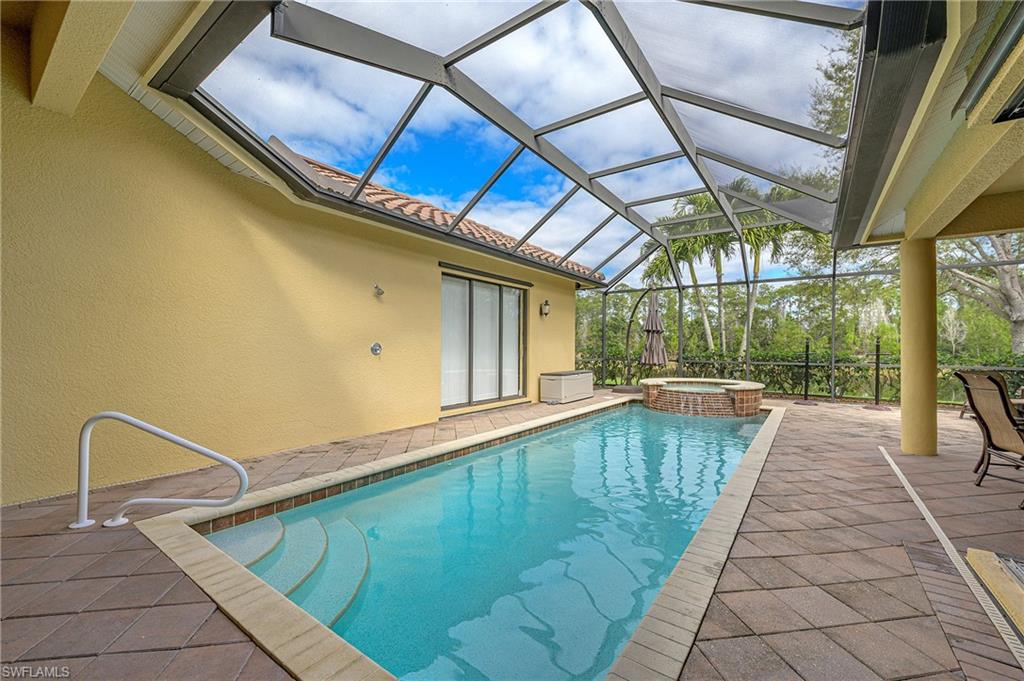 View of pool with a patio area, a lanai, and a pool with connected hot tub