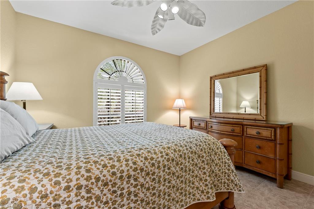 Bedroom with baseboards, ceiling fan, and light tile patterned flooring