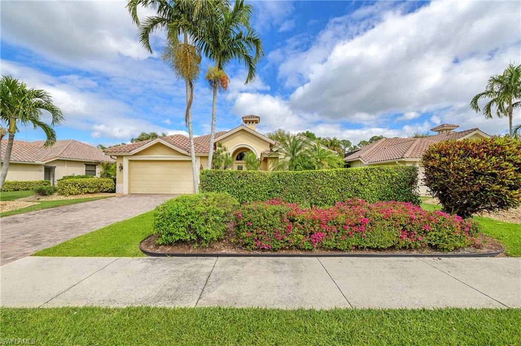 View of front of property with stucco siding, driveway, a garage, and a tiled roof