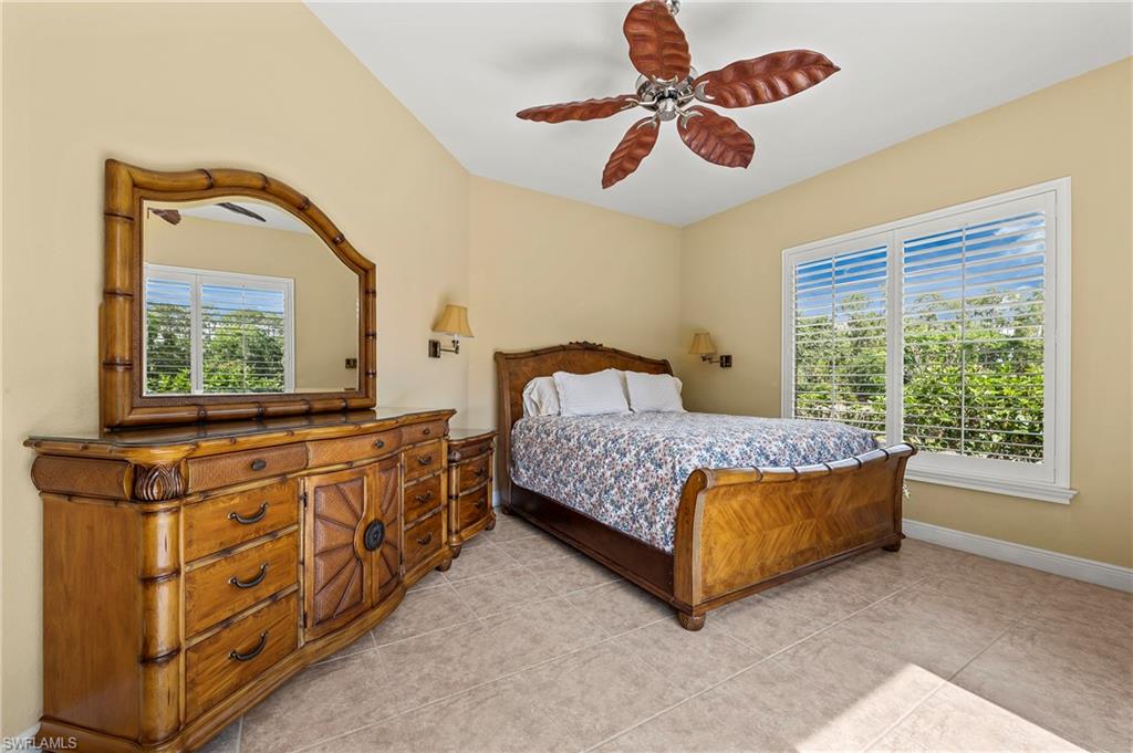 Bedroom with baseboards, a ceiling fan, and light tile patterned floors