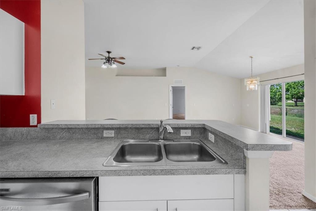 Kitchen featuring a dual basin stainless steel sink, a gray countertop, white cabinetry, and a stainless steel dishwasher