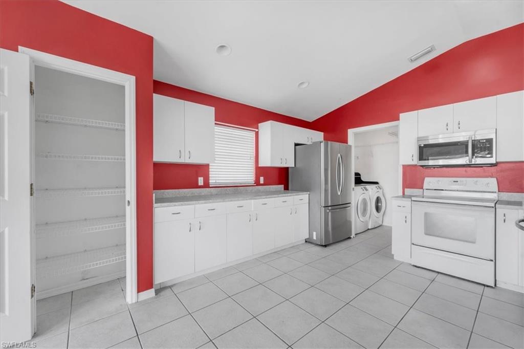 Kitchen featuring white cabinetry, light-toned countertops, and tile flooring
