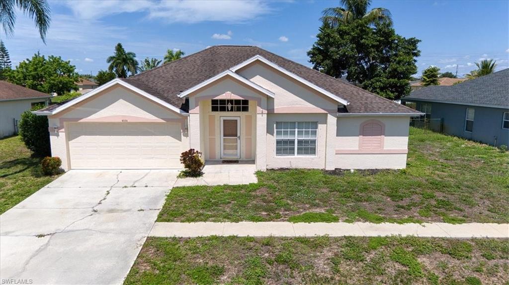 Single-story residence featuring a neutral stucco exterior with contrasting trim, a two-car garage, a covered front entry, and multiple windows