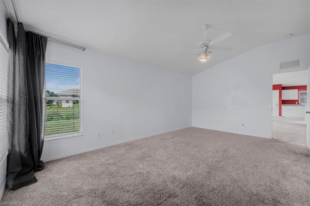 Spacious interior room featuring light gray carpeting and white painted walls