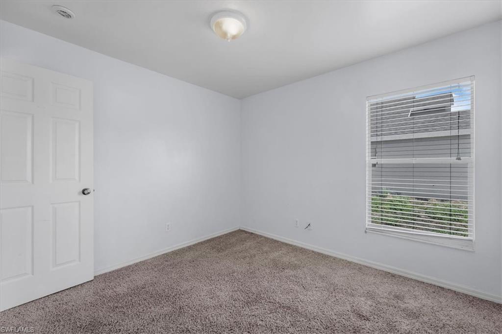 Neutral-toned wall-to-wall carpeting and bright white walls establish a versatile interior