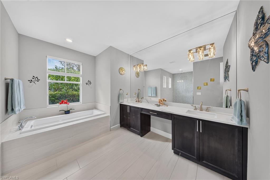 Dual vanity with dark wood-finish cabinetry, integrated sinks, and polished chrome fixtures