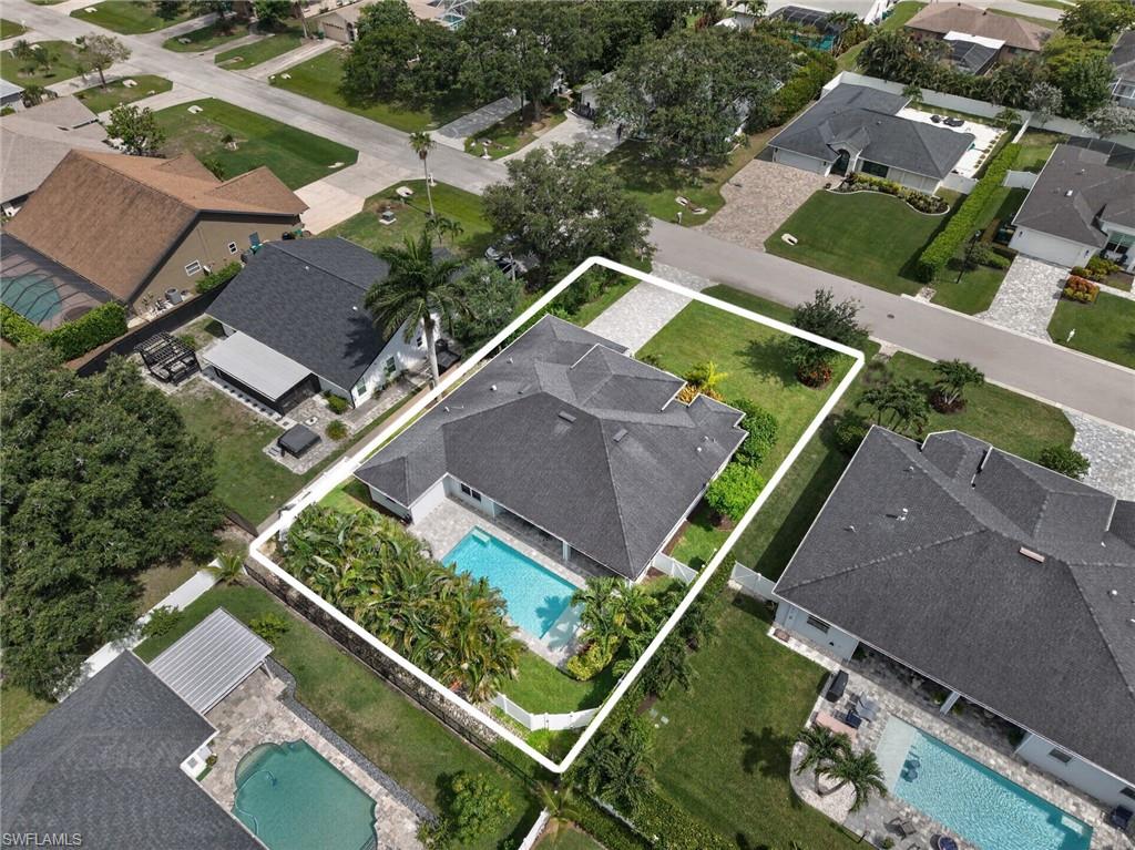 Aerial perspective showcasing a single-story residence with a dark shingle roof