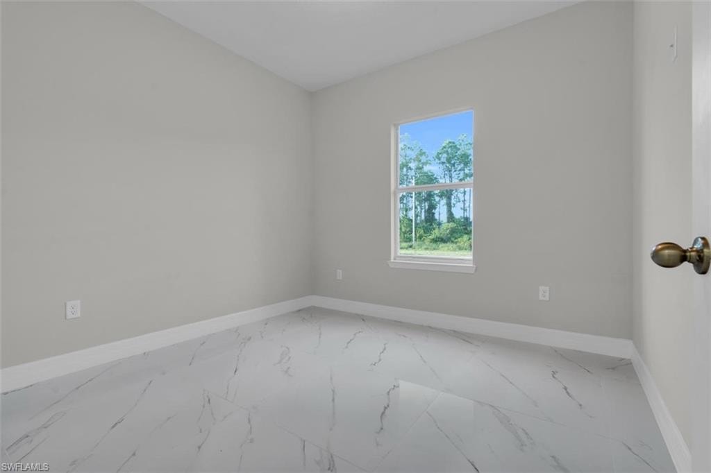 Bright interior space featuring light grey walls, white baseboards, and a single window with white trim