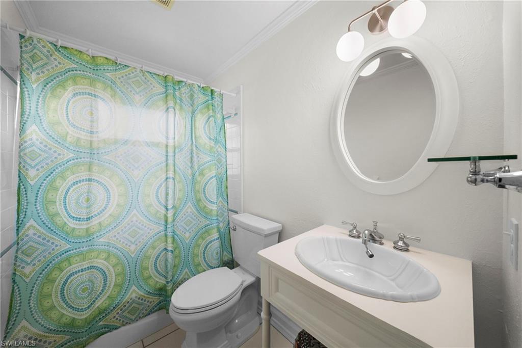 Bathroom featuring a white vanity with an undermount sink, dual-handle faucet, and an oval framed mirror