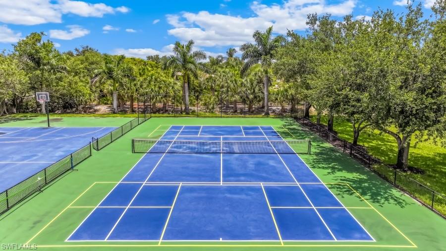 Private recreational area featuring a tennis court, basketball court, and lush surrounding landscaping