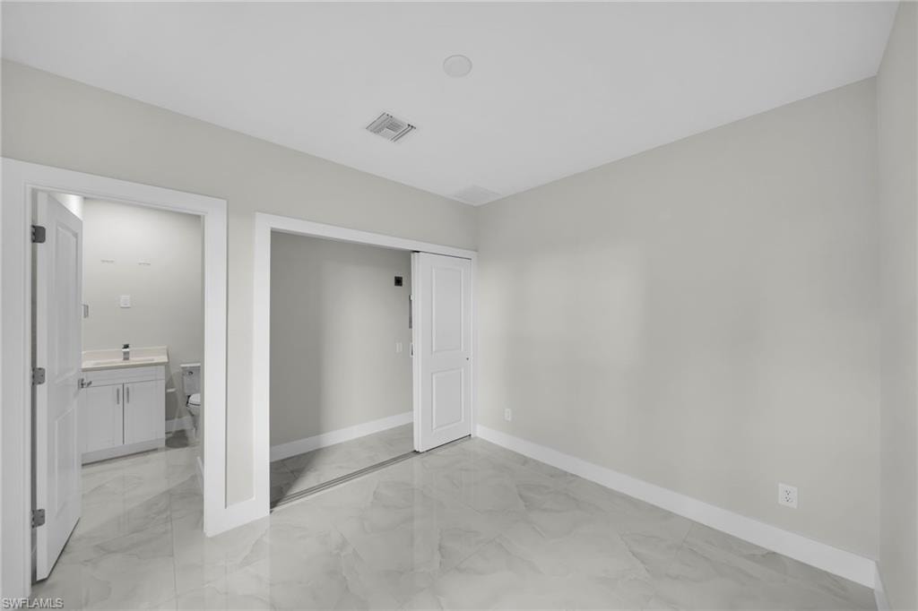 Spacious interior featuring marble-finish tile flooring, neutral wall tones, and white trim