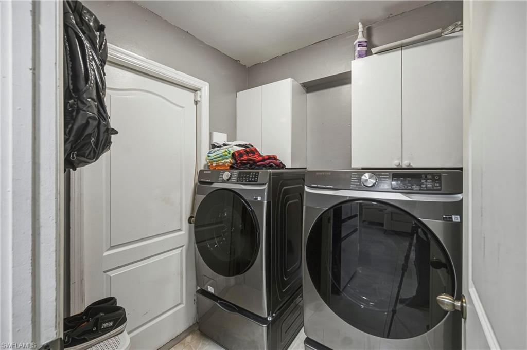 Laundry area featuring white cabinetry, gray wall paint, white trim, and a white interior door