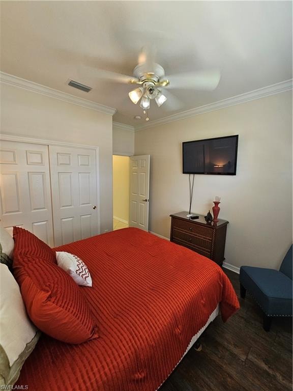 Bedroom with crown molding, wood finished floors, a closet, and a ceiling fan